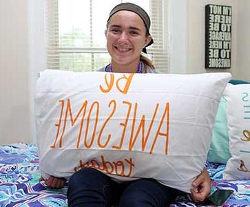 澳门在线赌城信誉网址学院的学生在她的宿舍里拿着一个枕头 